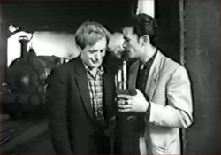 David McCallum as 'Johnny Murphy' under the Overhead Railway as a Dock Railway train approaches [Rank Films]